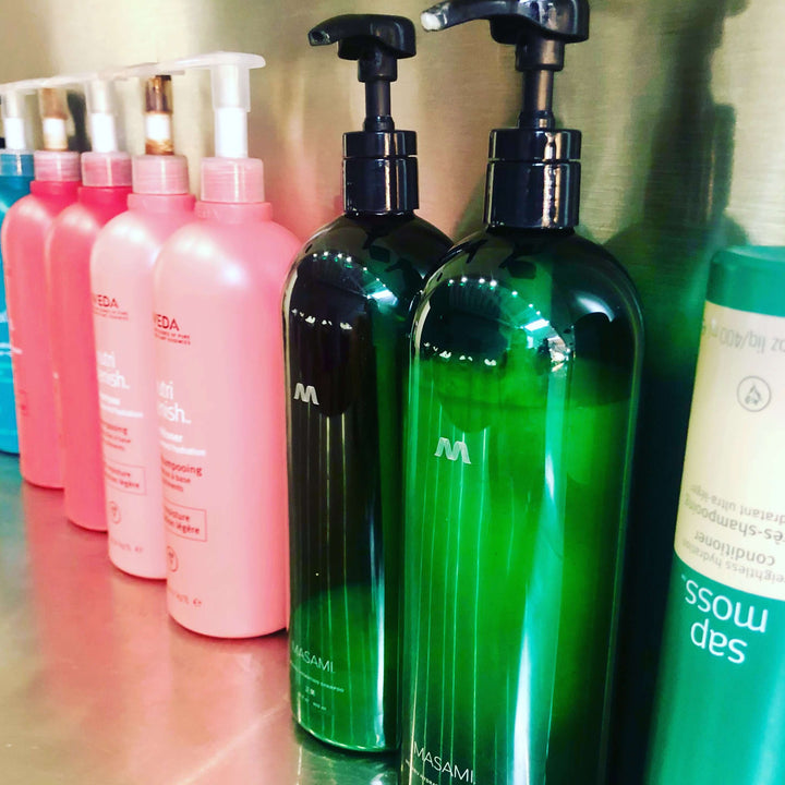Two bottles of Mekabu Hydrating Shampoo with other salon hair products on display