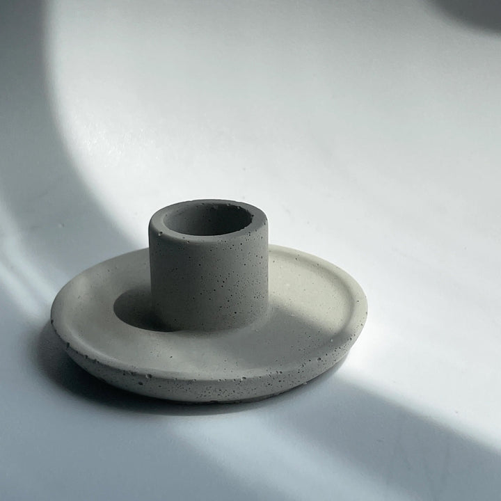 Minimalist handmade concrete candle holder fitting standard taper candles, crafted in Canada, showcasing simple, elegant design.
