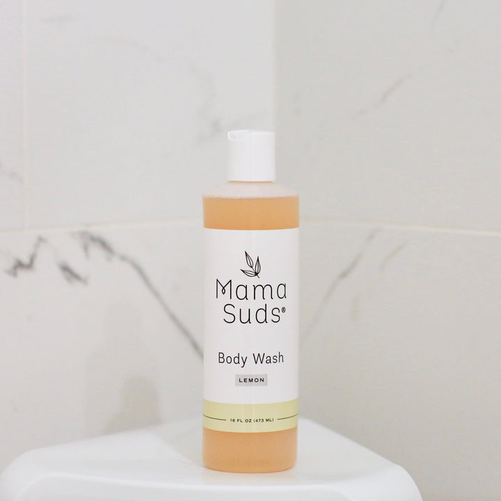Plant based body wash with lemon scent in a bottle; ingredients include distilled water, olive oil, essential oils; labels may vary.