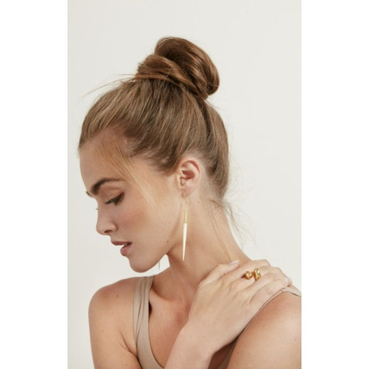 Woman wearing Capped Quill Minimalist Dangle Earrings with elegant updo hairstyle.