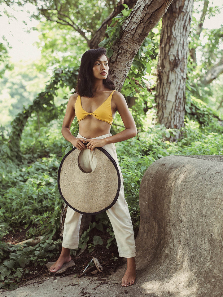 Woman holding Solo Halo Jute Bag in a natural setting, showcasing its circular shape and stylish design.