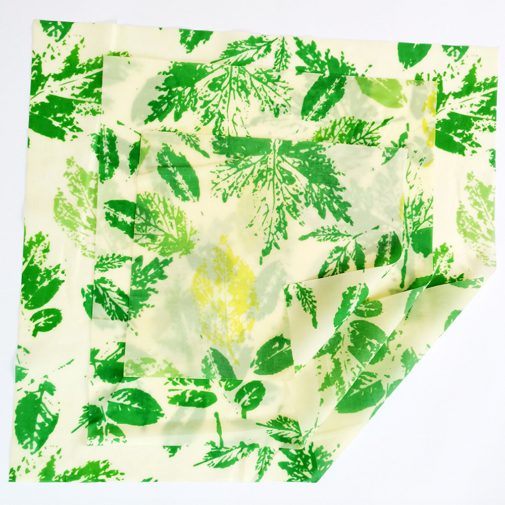 Green and yellow leaf-patterned beeswax reusable food wrap, eco-friendly alternative to single-use plastic.