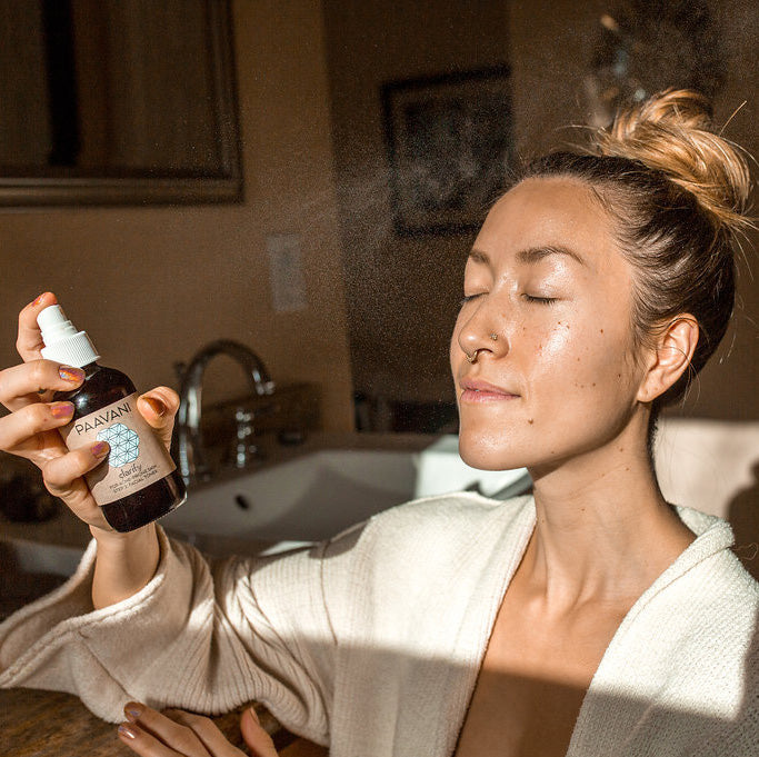 Woman using Clarify Skincare Ayurvedic spray for blemish-prone skin, promoting clarity and balance in skincare ritual.