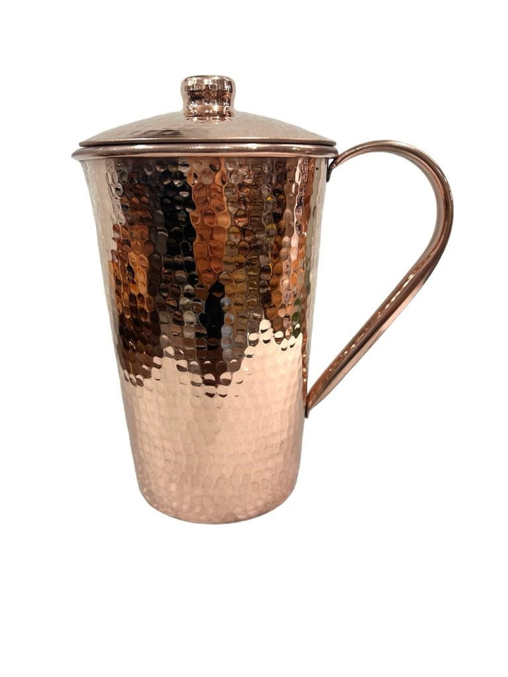 Hammered copper pitcher with lid, featuring a shiny finish, perfect for serving beverages in style.