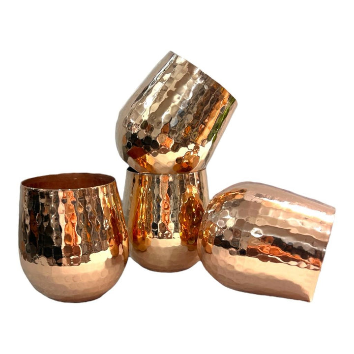Hammered copper tumblers with a shiny finish, displayed on a white background. Elegant and durable, perfect for any beverage.