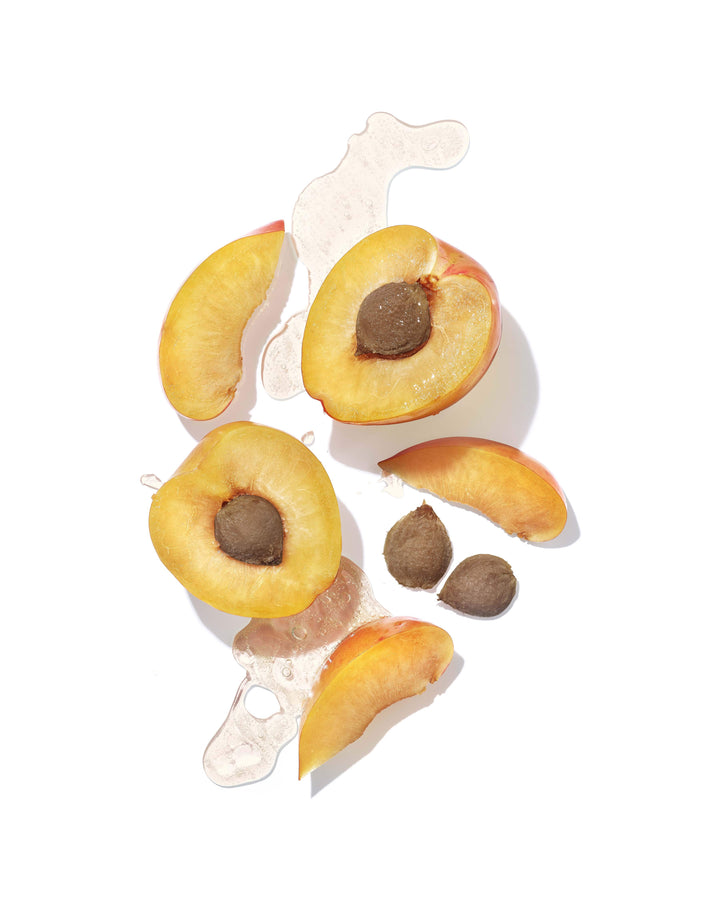 Sliced apricots with seeds and juice, highlighting natural ingredients in Mekabu Hydrating Shampoo for nourishing and hydrating hair.