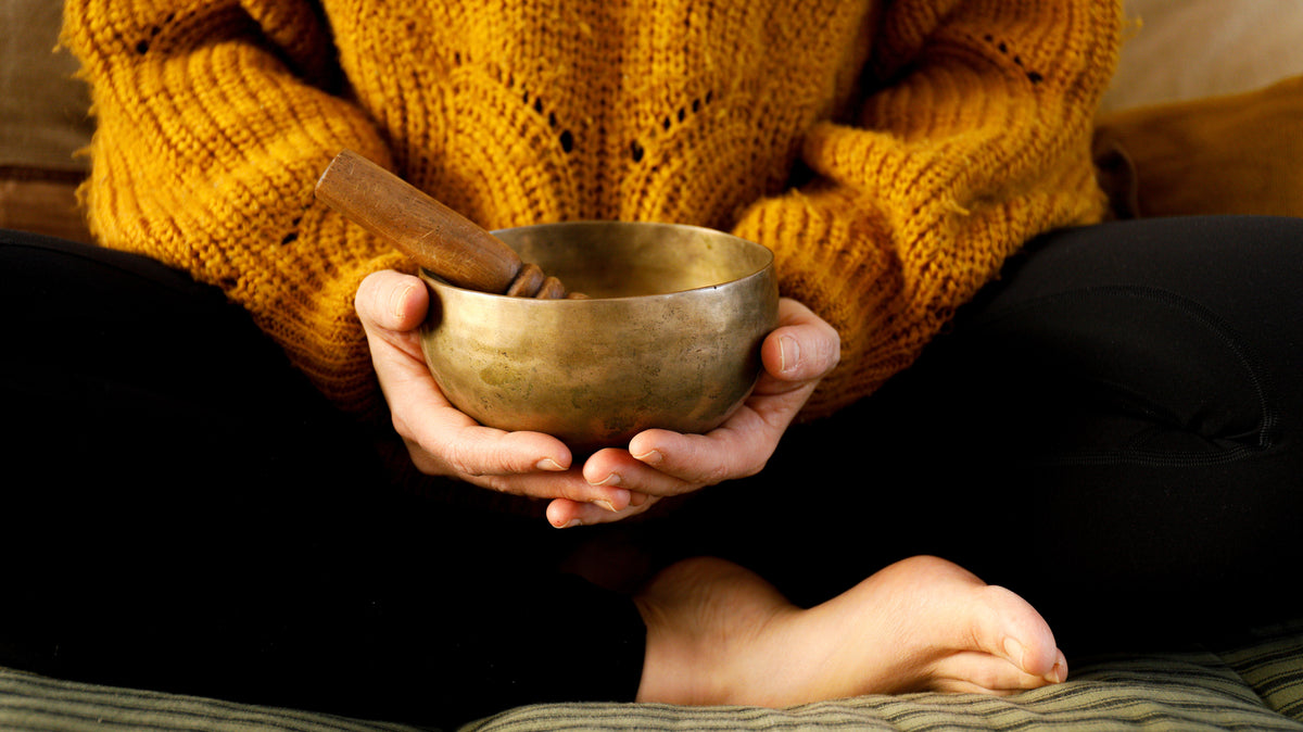 Hands holding a brass singing bowl