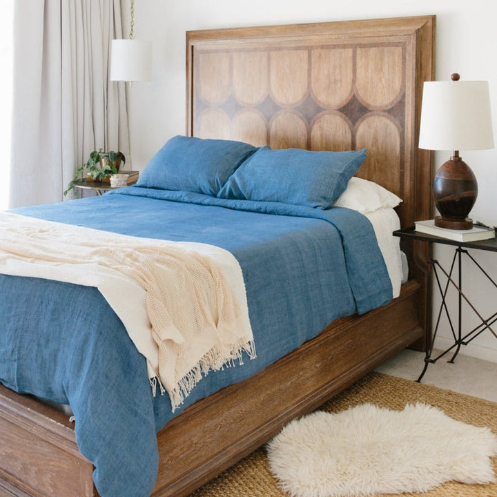 Denim Blue Linen Duvet Cover Set on wooden bed with rug, showcasing cozy and stylish bedroom decor.