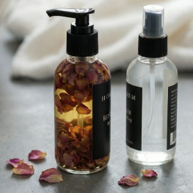 Natural Clean Beauty Products with Floral Essence in Stylish Bottles on a Gray Surface, Showcasing an Elegant Beauty Care Collection.