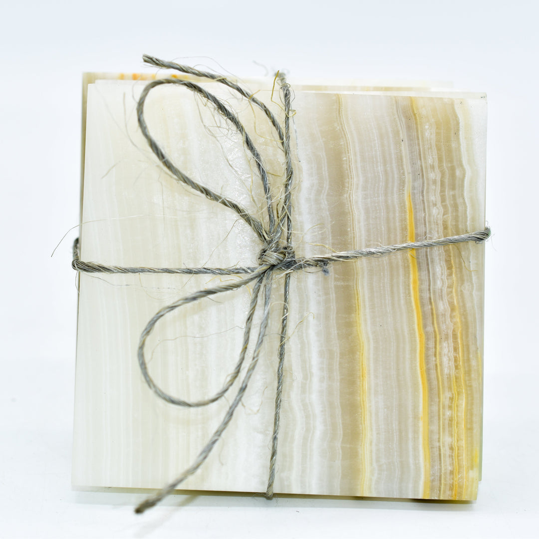 Handcrafted Artisan Gifts - Natural stone coasters tied with rustic twine, featuring elegant striations and earthy tones.