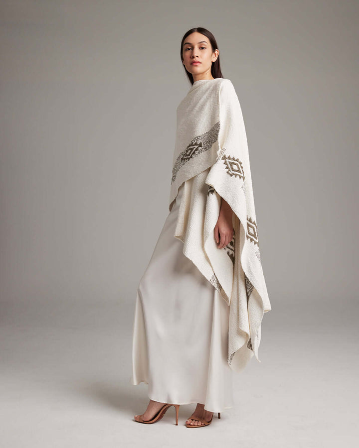 Model wearing Long Estrella Textured Cotton Duster, a hand-loomed poncho with Estrella symbol, made from organic Pima cotton by Mapuche artisans.