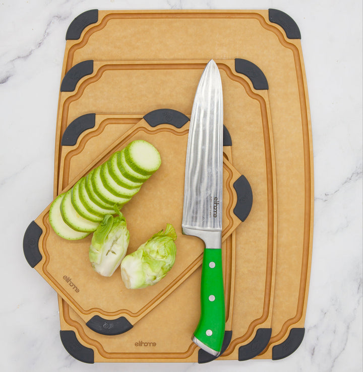 Reversible cutting board set with food icons and juice groove design on kitchen counter with vegetables