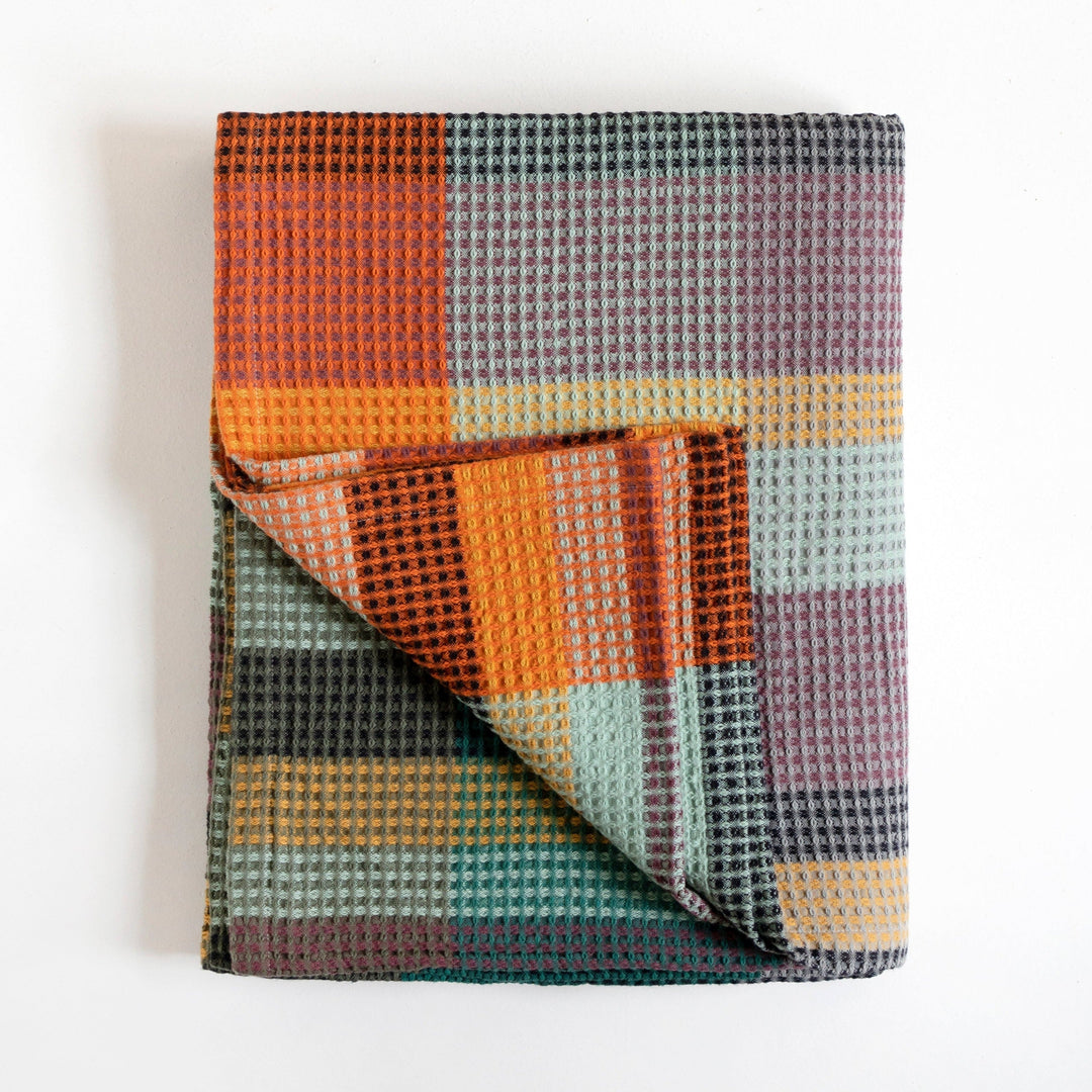 Vrou Vrou Textured Blanket in Cypress with colorful geometric pattern, 100% cotton, designed in South Africa, folded on white background.