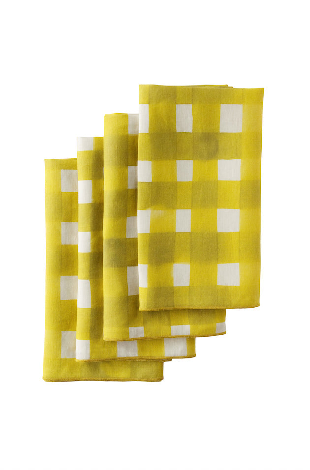 Yellow cross-hatch linen napkins with painterly brushstrokes arranged on natural wooden table