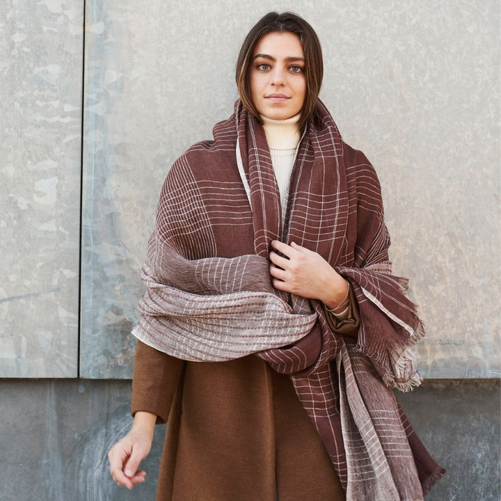 Handwoven linen scarf in cinnabar rust with undyed white accents draped naturally showing translucent texture
