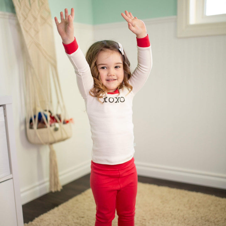 Toddler organic cotton pajamas with XOXO typewriter font design featuring wide elastic waistband in natural eco-friendly dyes