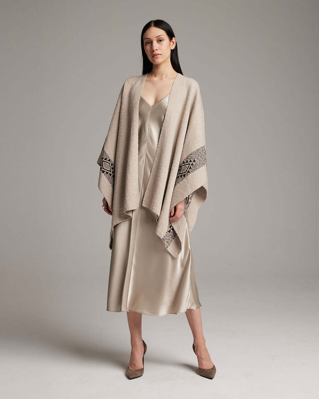 Woman wearing Long Estrella Textured Cotton Duster handcrafted by Mapuche artisans, featuring Estrella symbol, over a satin dress.