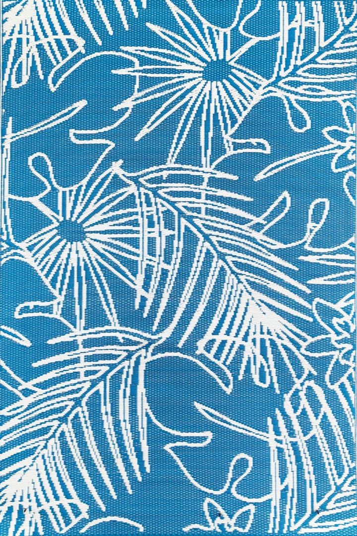 Turquoise and white palm leaf pattern outdoor rug made from recycled plastic on wooden deck