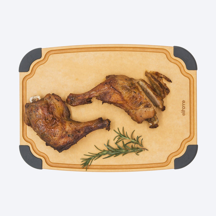 Reversible wood cutting board with juice groove and food icons on kitchen counter