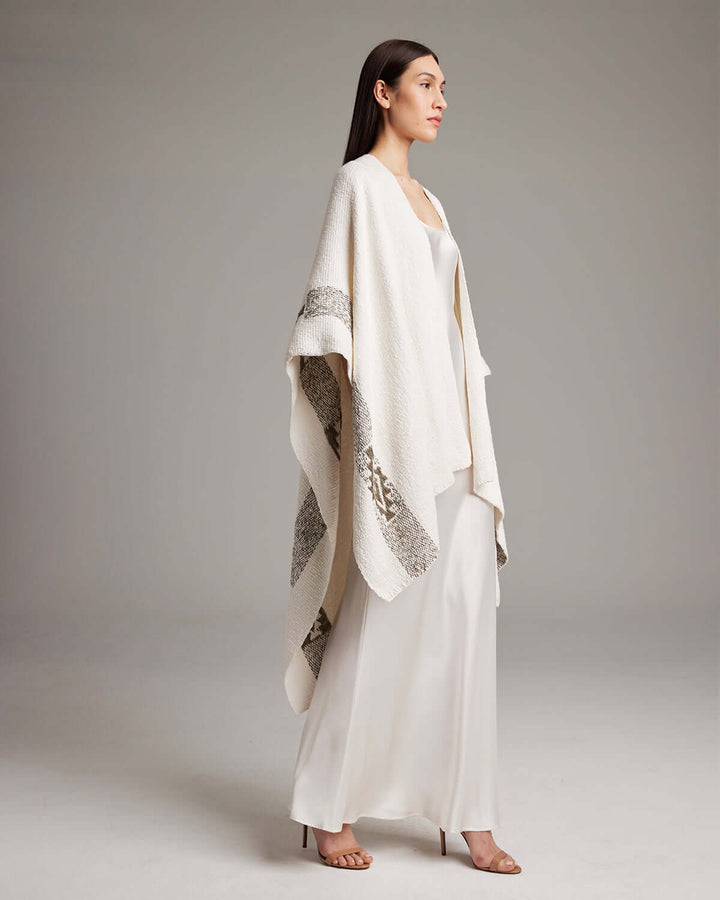 Model wearing Long Estrella Textured Cotton Duster, hand-loomed poncho by Mapuche artisans, featuring divine femininity symbol.