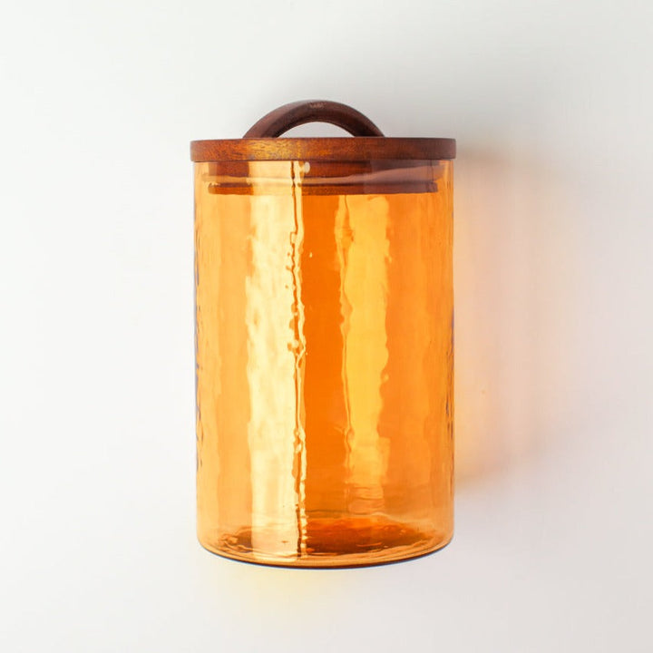 Amber glass canister with a hand-carved wooden lid, perfect for kitchen storage or as an apothecary jar. Recycled glass. Made in India.