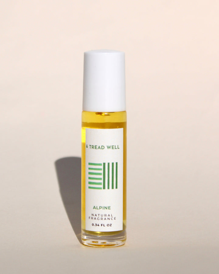 Natural Alpine fragrance bottle with woody cedarwood and balsam scent blend on rustic wooden surface