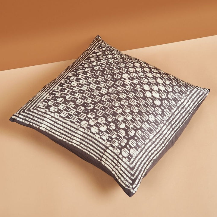 Handcrafted black and white geometric wax block print silk pillow on neutral background