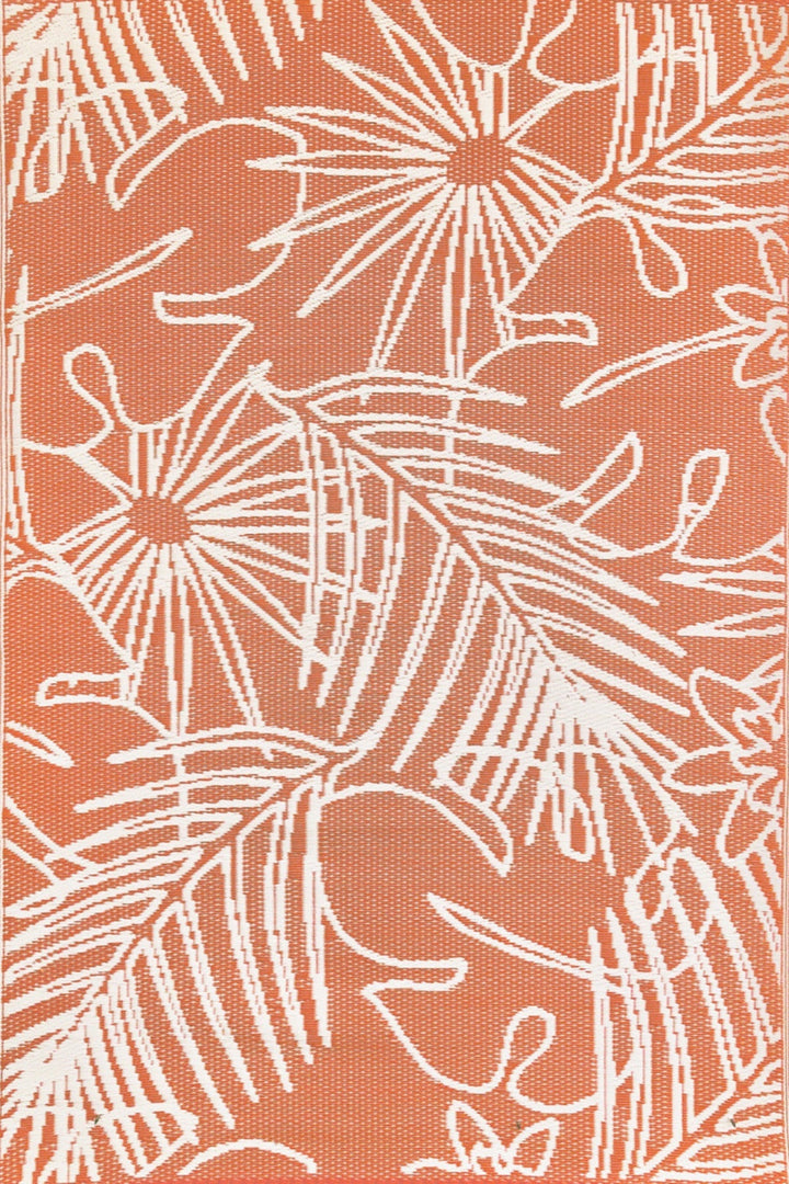 Handwoven salmon and white palm leaf pattern outdoor rug made from recycled plastic on wooden deck