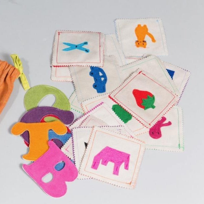 Colorful handmade phonics matching game with felt letters and picture cards in cotton storage bag