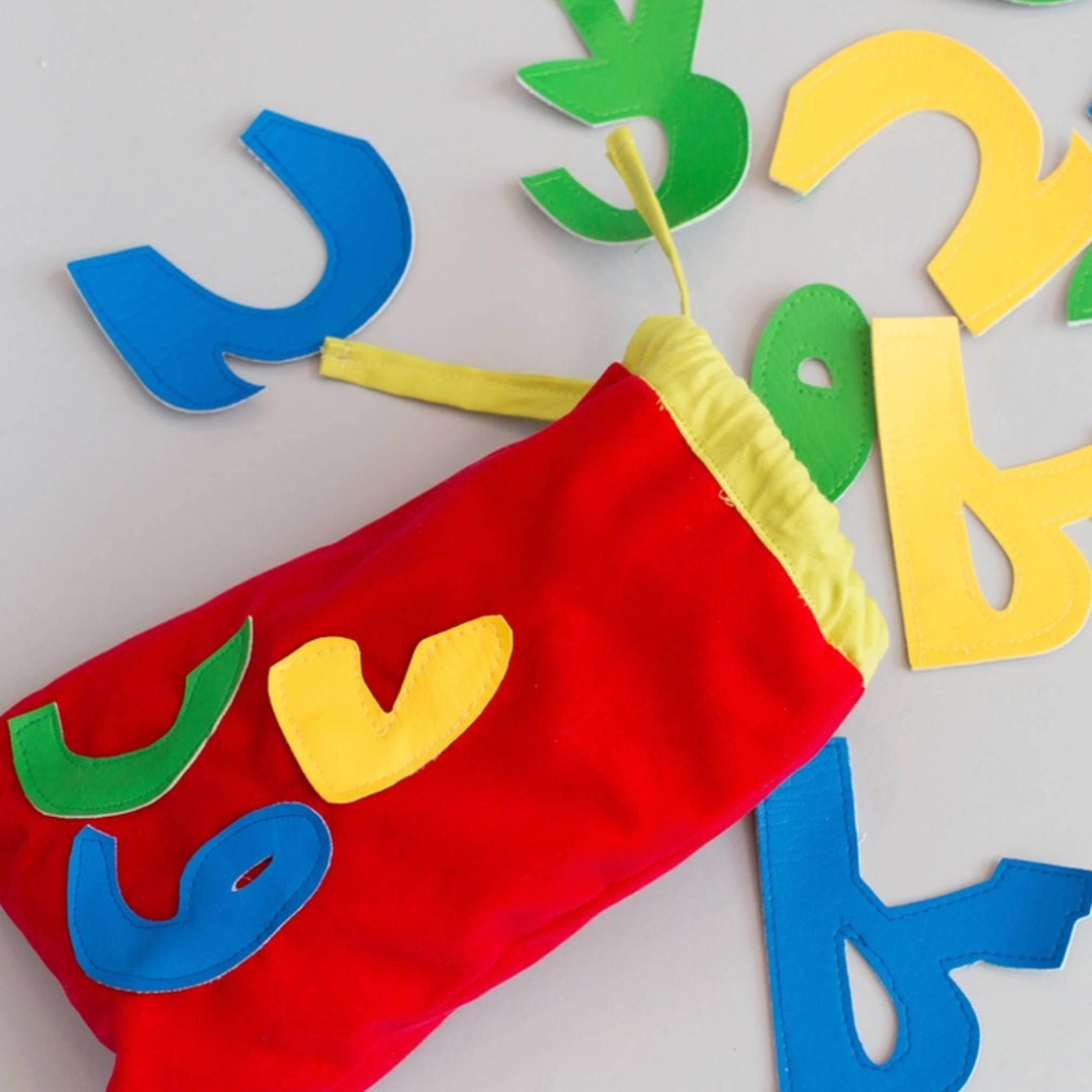 Colorful handmade Arabic alphabet letters made from soft felt and cotton in a compact storage bag