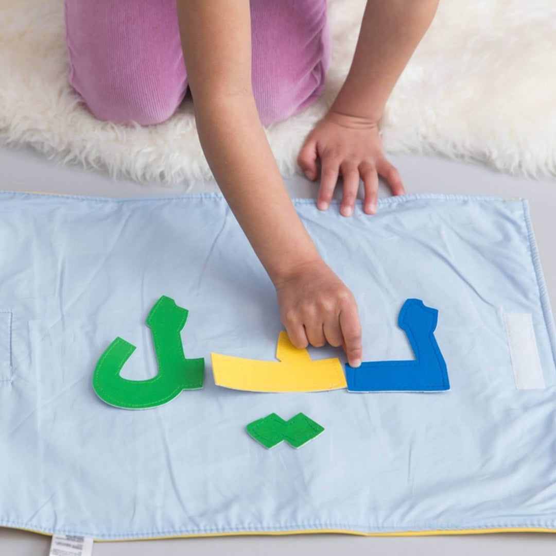 Arabic alphabet spelling mat with colorful felt letter pieces arranged on fabric play surface