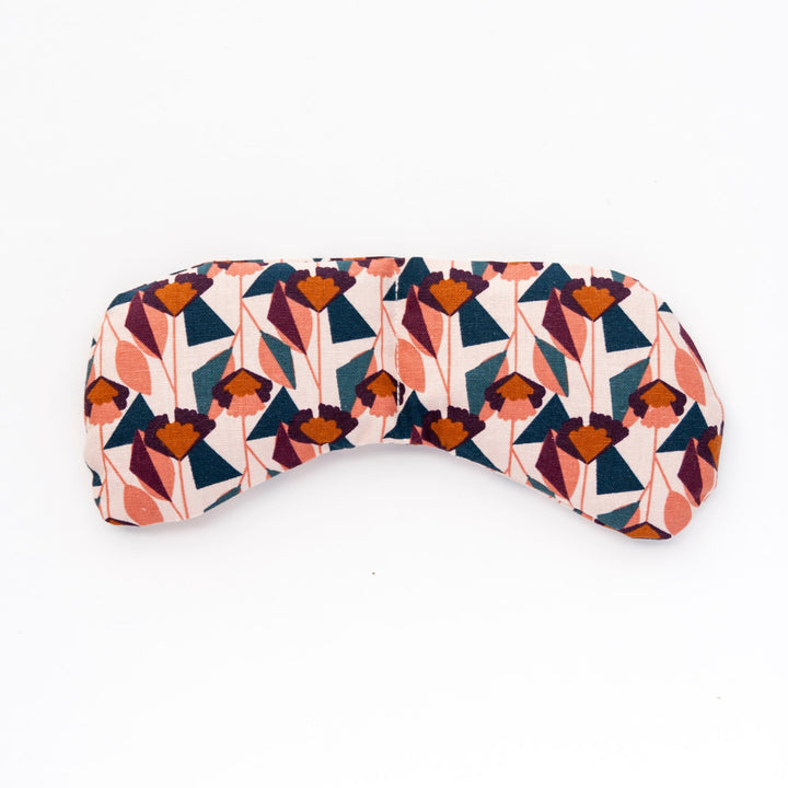 Weighted eye mask with a colorful geometric pattern for migraine relief and tension ease, perfect for warm or cold application.
