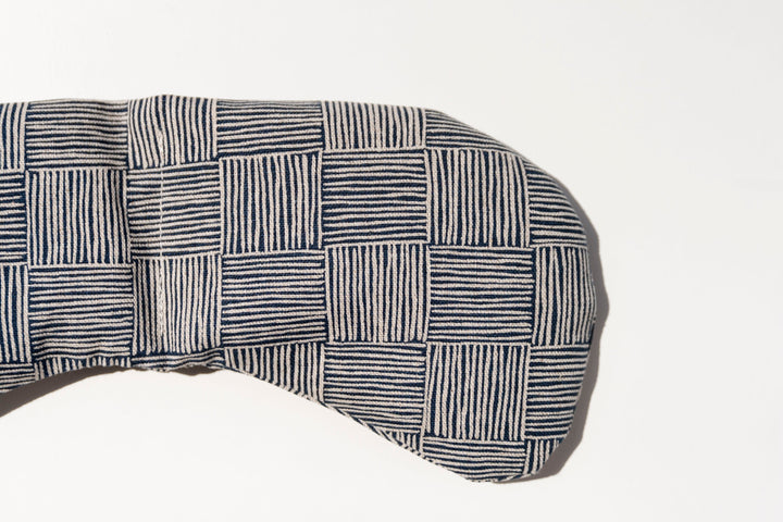 Weighted eye mask with a neutral, timeless textural pattern for tension and migraine relief.