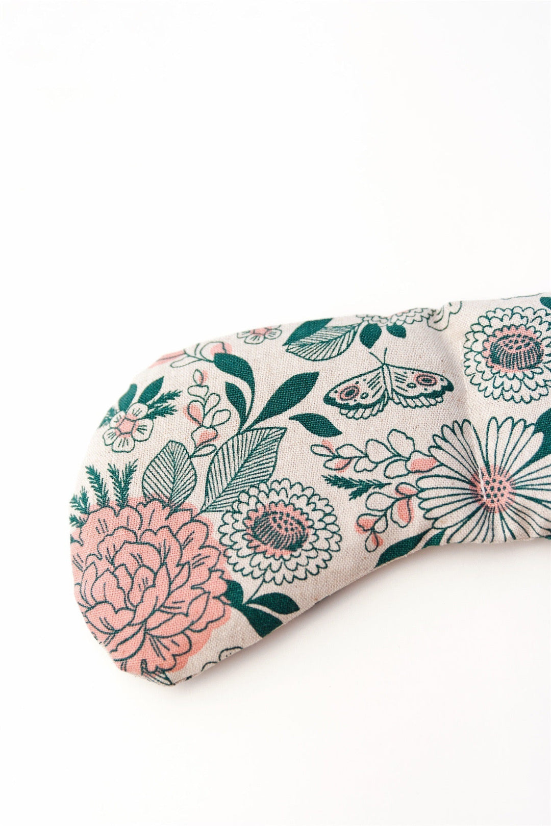Floral patterned weighted eye mask for migraine relief featuring pink and green design on fabric background.