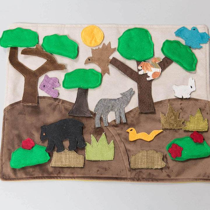 Handmade felt forest habitat storyboard with woodland animals and nature pieces on cotton play mat