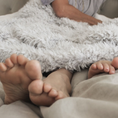 Soft Angel Plush Blanket covering feet, creating a cozy and serene atmosphere in a home setting