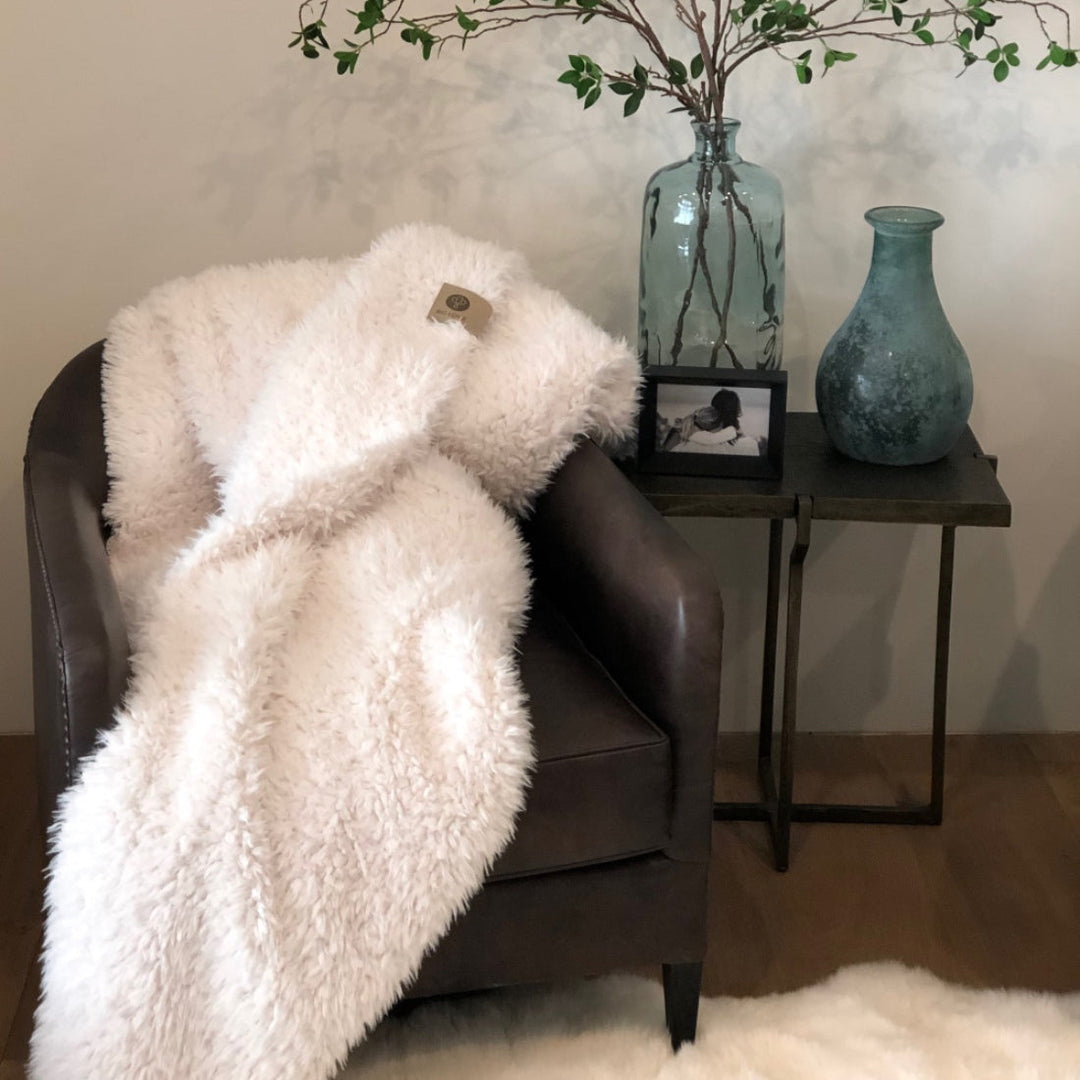 Angel Plush Blanket draped on a chair, showcasing soft texture and elegant design, perfect for adding tranquility to any home decor.