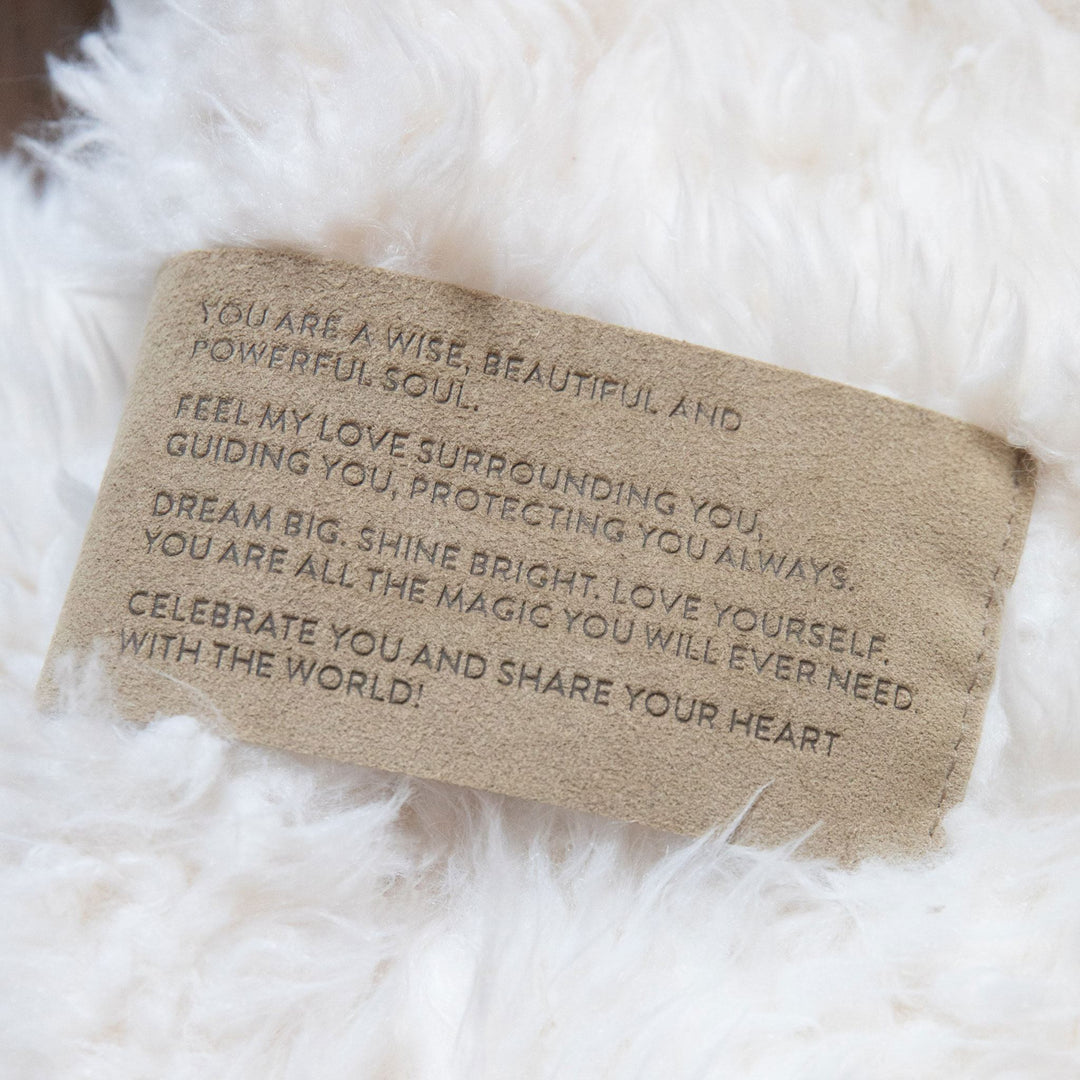 Motivational message on a plush white blanket reading "You are wise, beautiful, and powerful. Dream big, shine bright, love yourself."