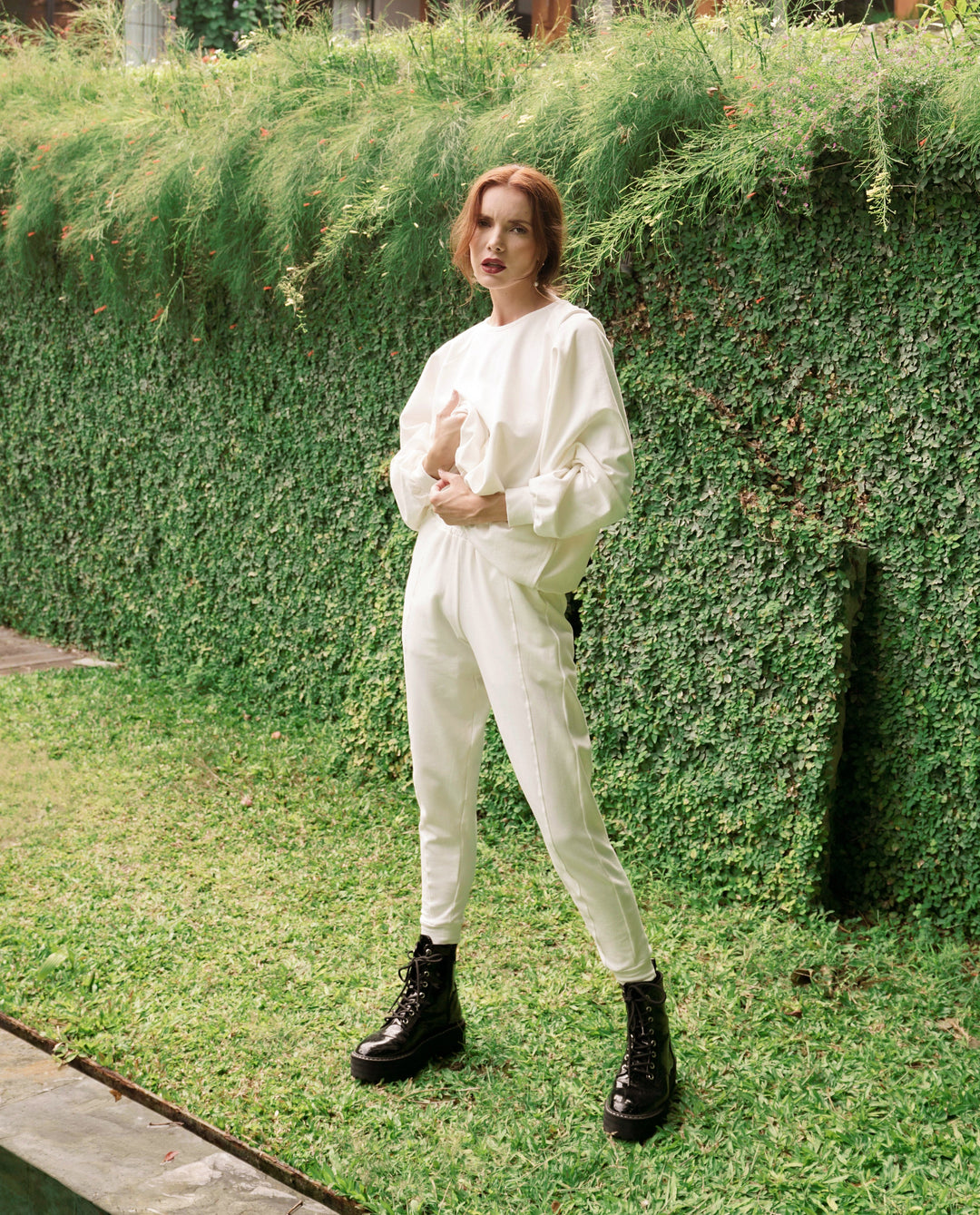 Woman wearing off-white Cameron Bamboo Joggers, standing in garden.