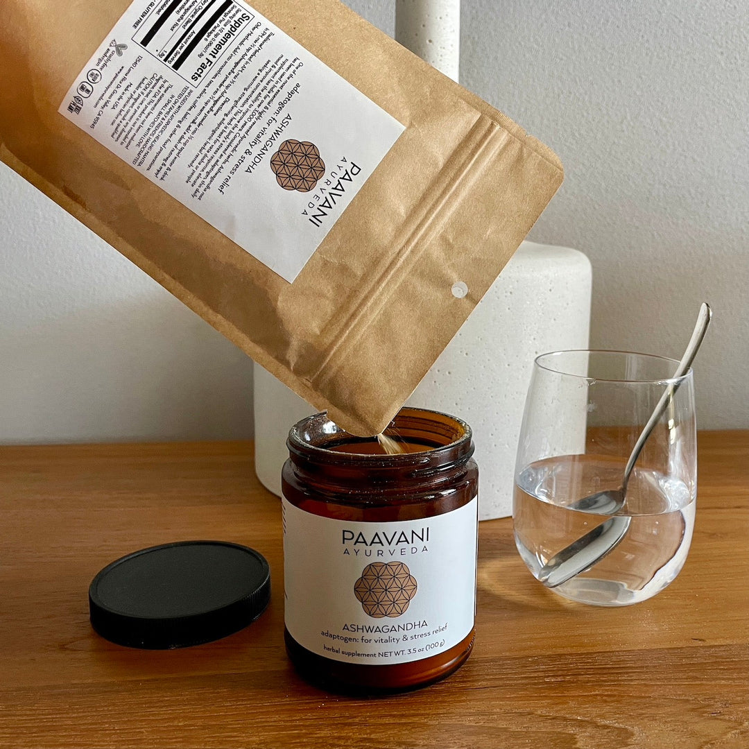 Ashwagandha Powder being poured into a jar, with a glass of water and spoon nearby, illustrating a daily adaptogenic supplement routine.