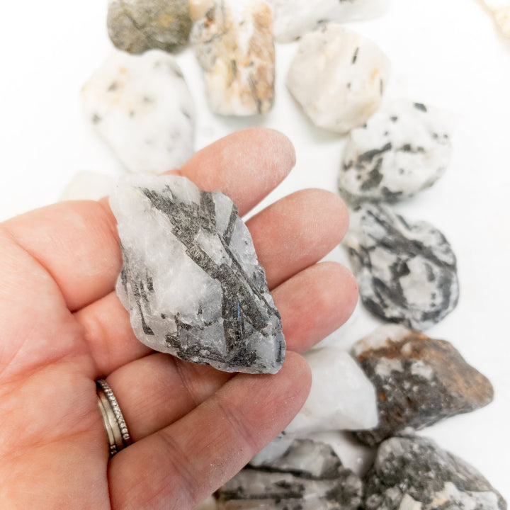 Natural tourmalinated quartz rough stone showing black tourmaline inclusions within clear crystal matrix