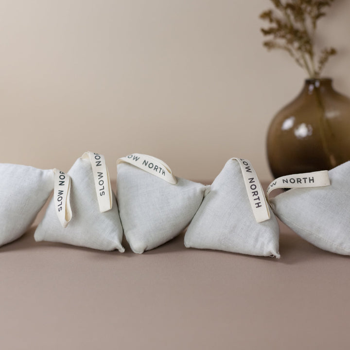 Cotton natural lavender sachets arranged in a row, ideal for freshening drawers, closets, or cars with calming aromatherapy benefits.