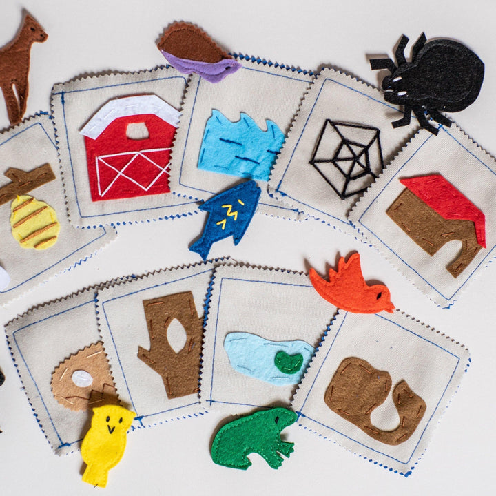 Handmade felt animal habitat matching game with carrying case showing 9 animals and habitat cards