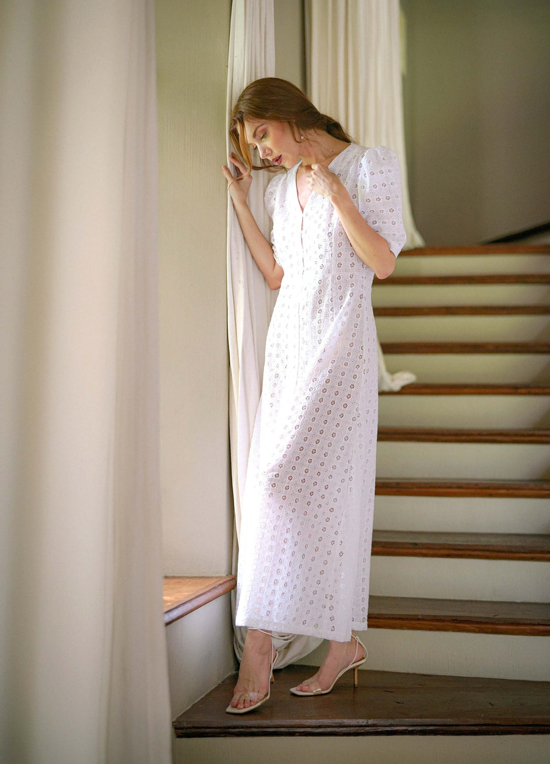 Model wearing Olympia Embroidered Cotton Dress in white, handmade in Bali, inspired by vintage gowns, highlighting feminine design.
