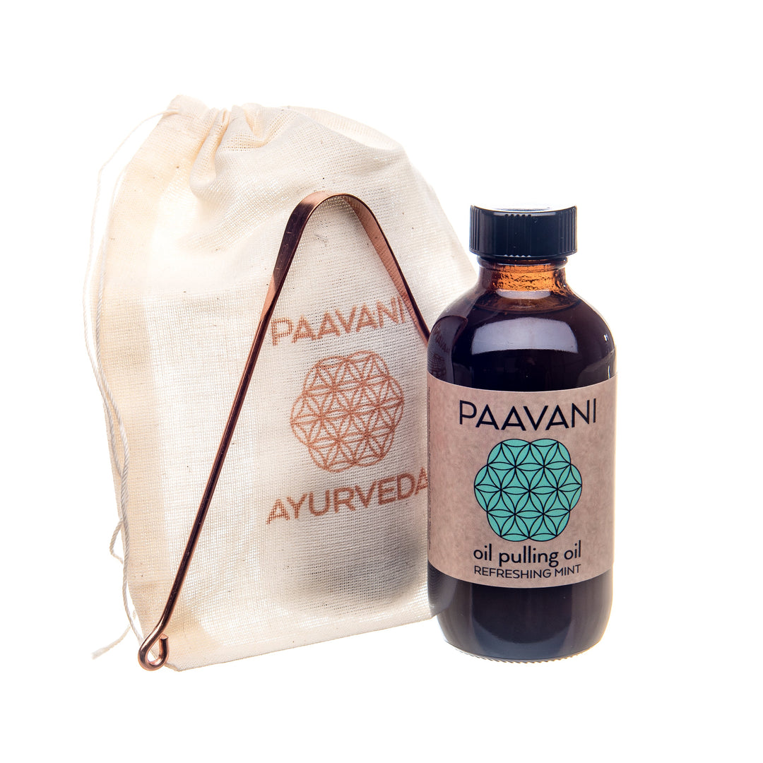 Ayurvedic oral care set with oil pulling bottle and tongue cleaner for digestive wellness and dental health.