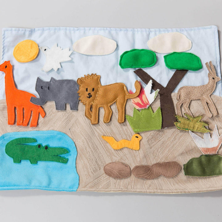 Handmade safari habitat storyboard with colorful felt animals and cotton playmat for creative educational play