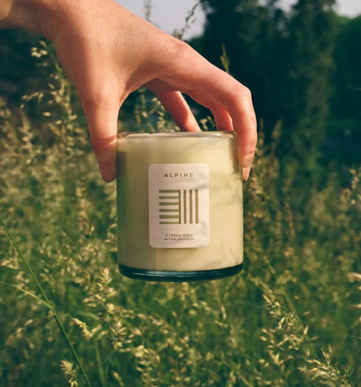 Natural soy candle with cedar wood aromatherapy blend in recycled glass jar on wooden surface