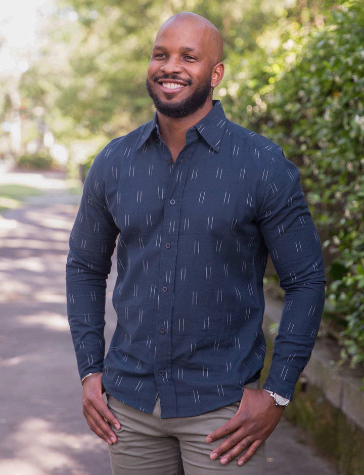 Navy ikat button down shirt with handwoven cotton fabric and slim fit tailoring displayed on wooden hangers