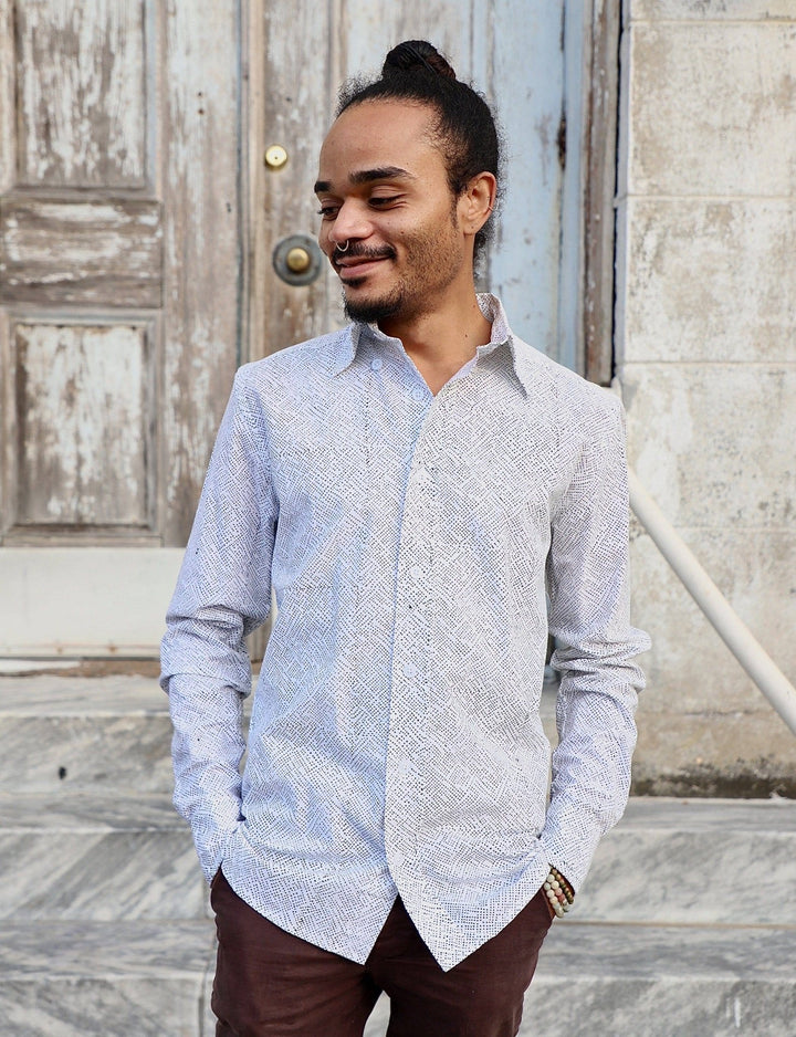 White organic cotton men's button down shirt with light blue dot print laid flat showing classic collar and cuffs