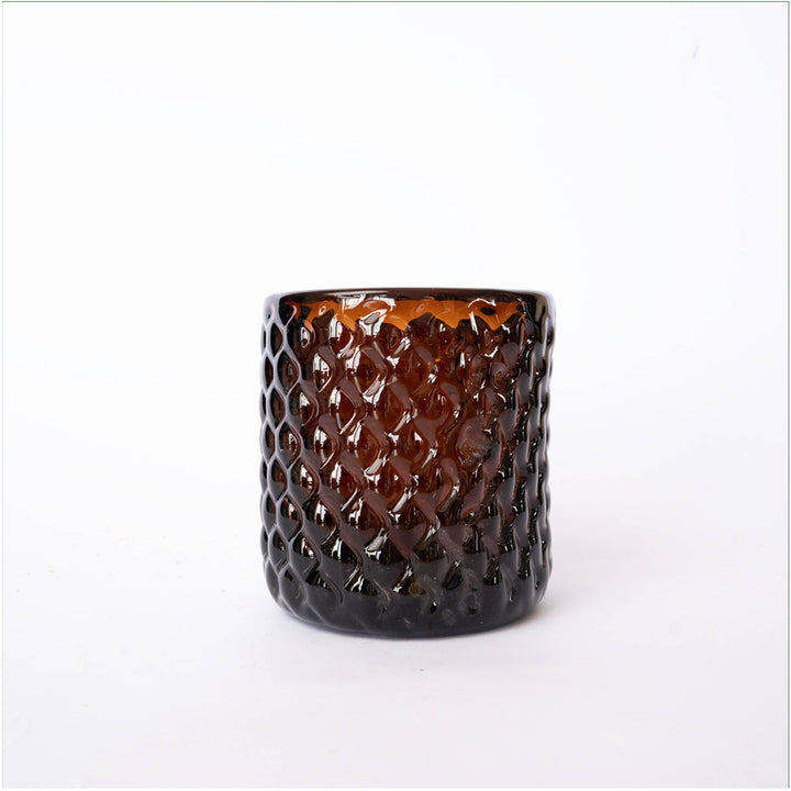 Set of handblown amber glass tumblers with warm golden tone on neutral background